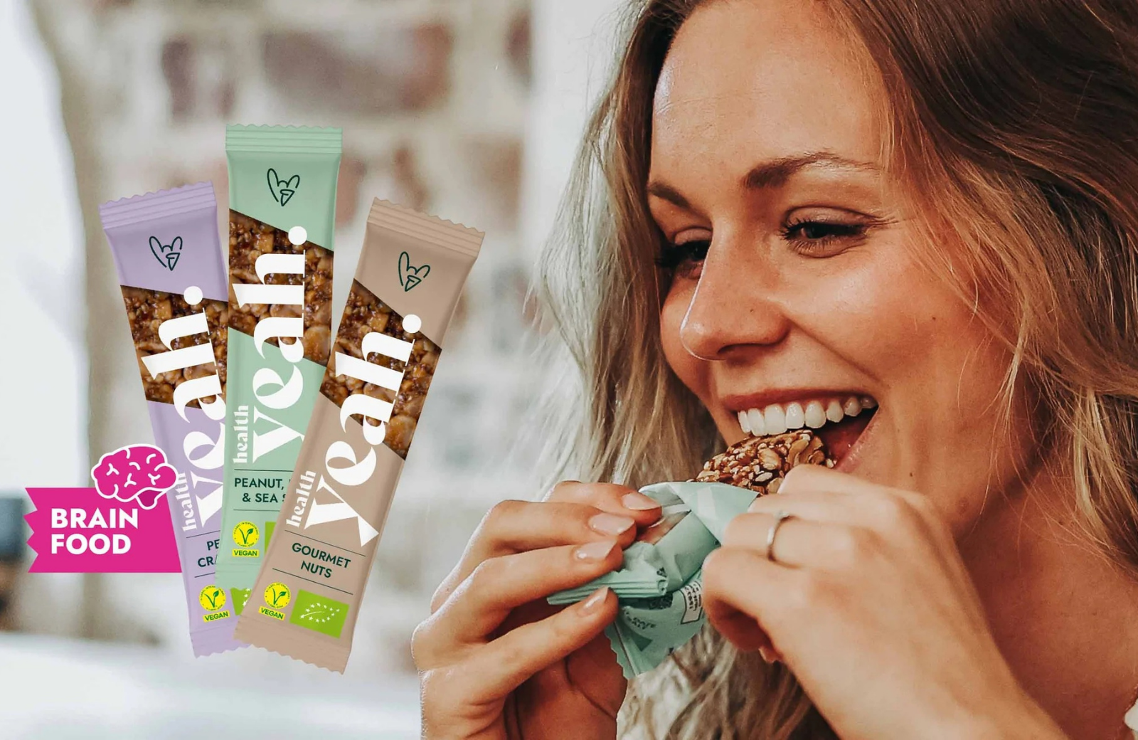 Woman eating a Health Yeah bar next to the brand's three product variants